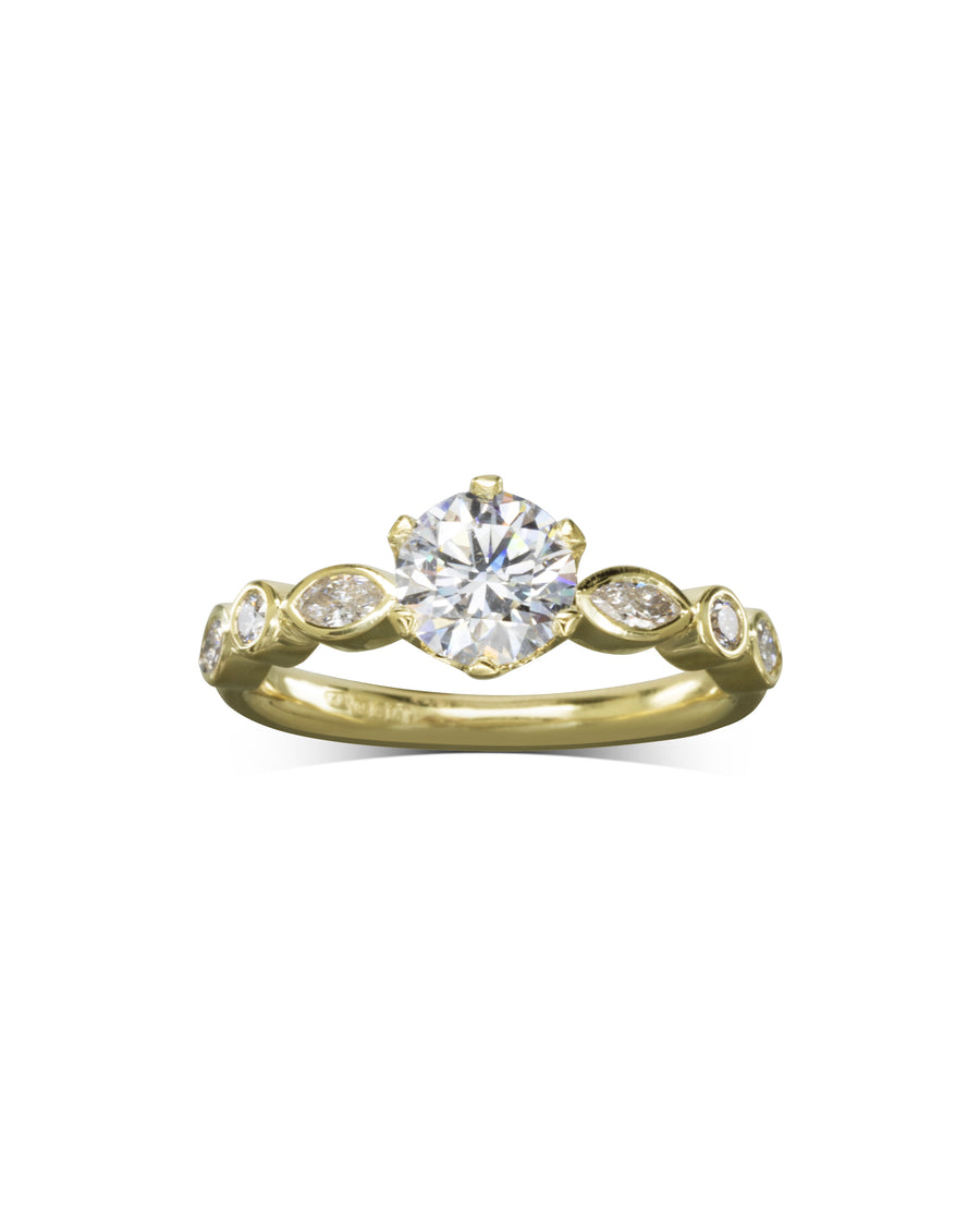Yellow gold engagement ring with a round cut diamond and marquise side stones.