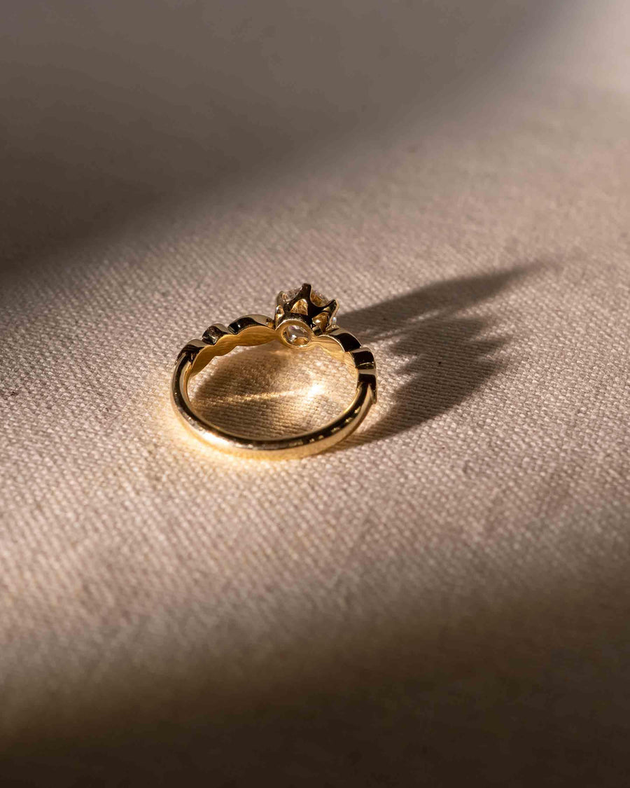 Gold engagement ring with a round cut diamond in a crown setting.