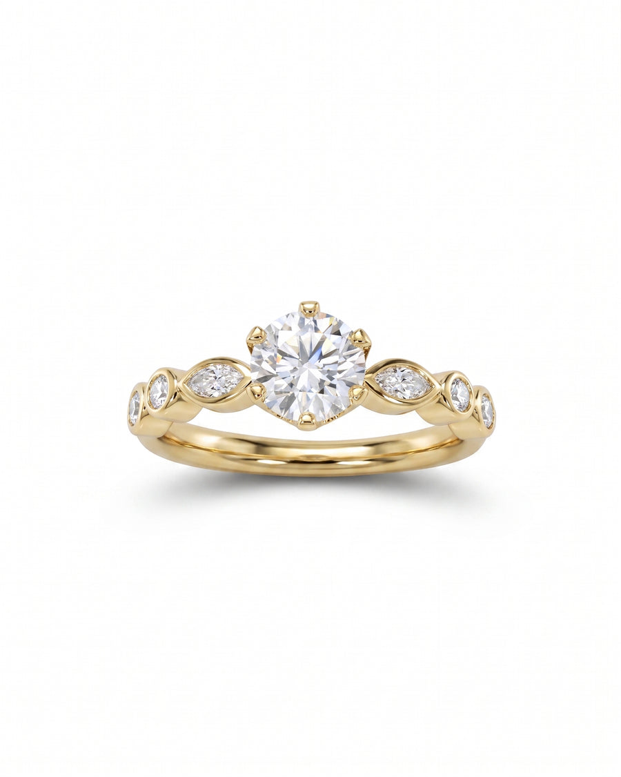 Yellow gold engagement ring with a round cut diamond and marquise side stones.