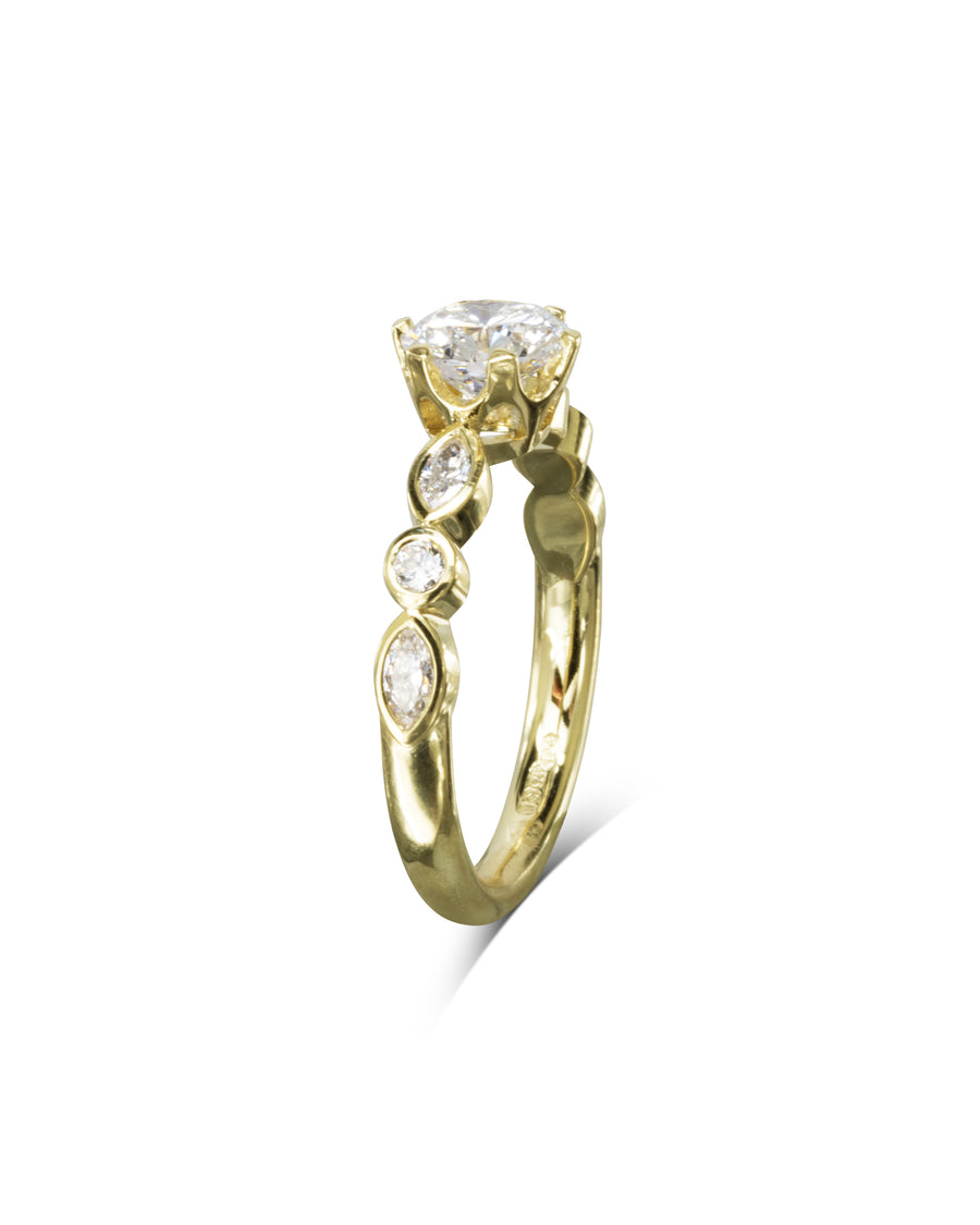 Gold engagement ring with a round cut diamond and smaller side diamonds.