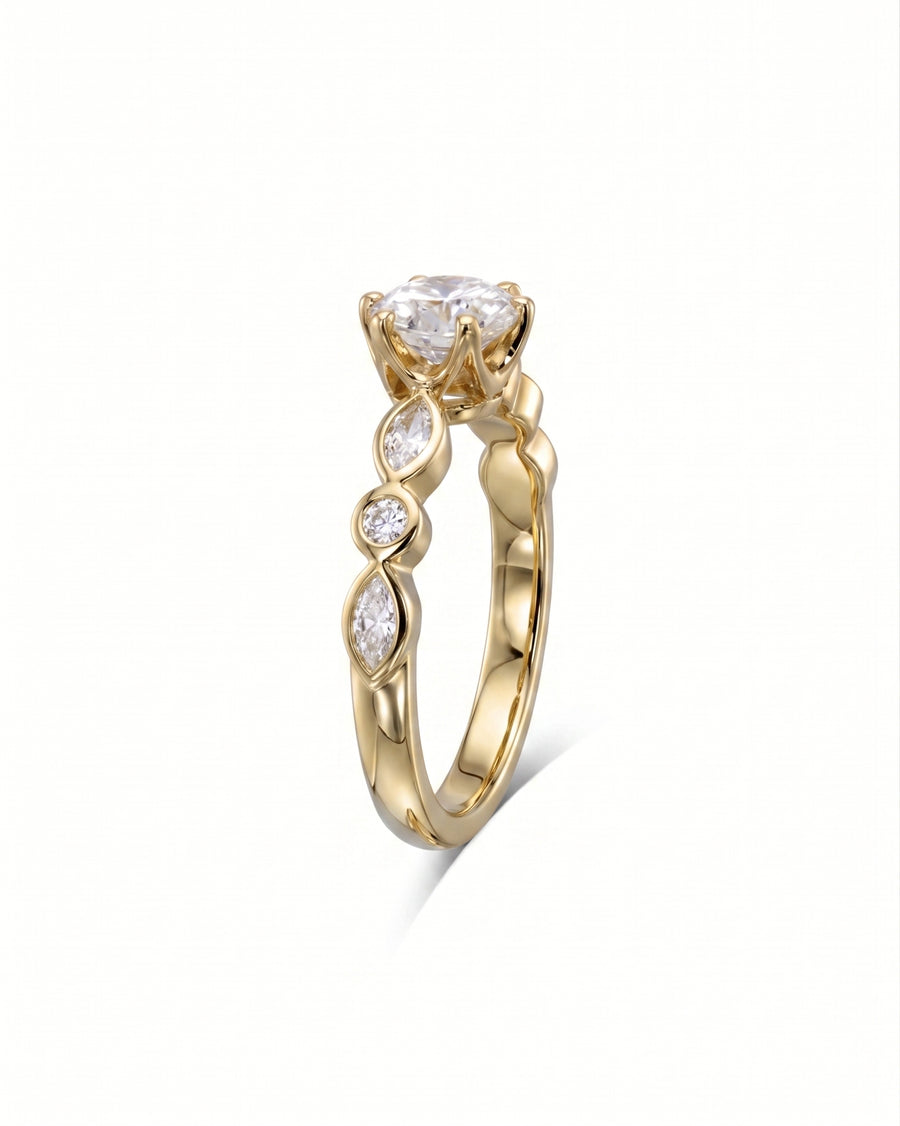 Gold engagement ring with a round diamond and marquise side stones.