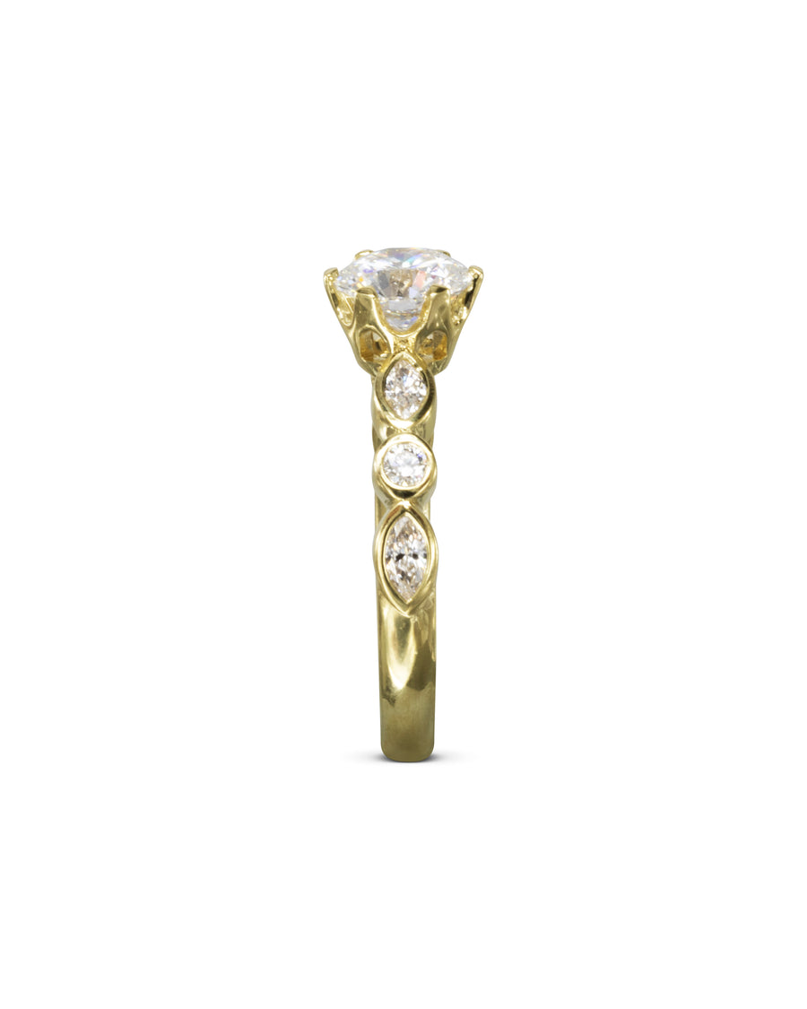 Gold engagement ring with a round cut diamond and three smaller side diamonds.