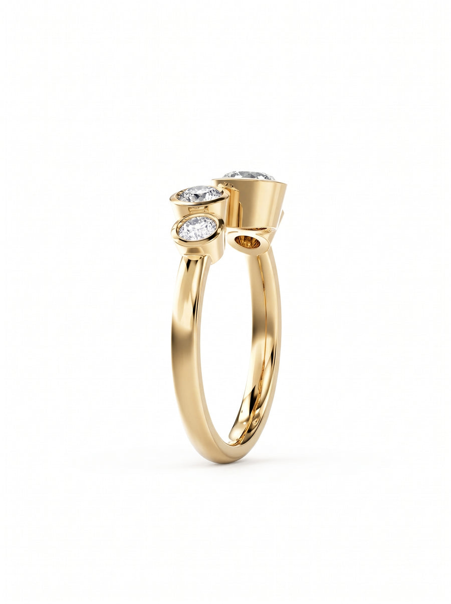 Gold engagement ring featuring four bezel-set round cut diamonds in a bubble-inspired design.