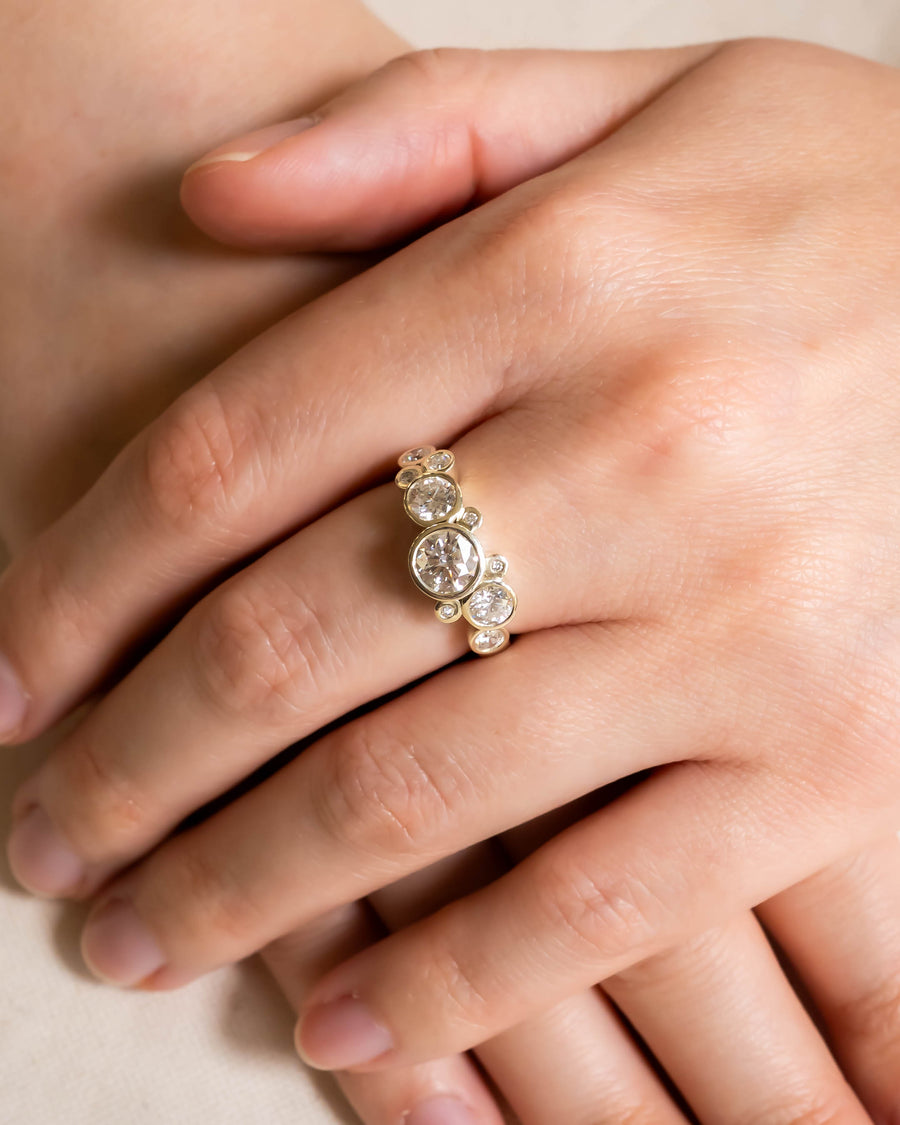 Gold engagement ring with round cut diamonds in a water bubble design.