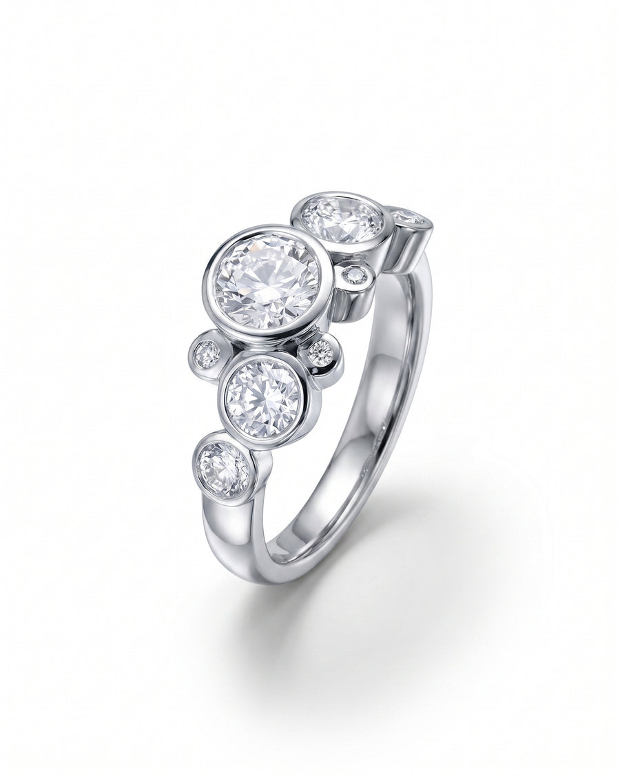 Silver engagement ring featuring multiple round-cut diamonds in a bezel-set bubble cluster design.