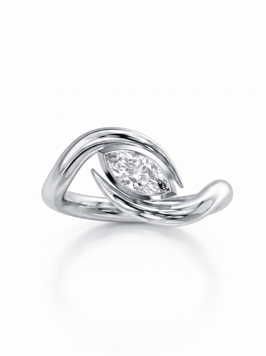 Silver engagement ring featuring a marquise cut diamond set in a swirling, spiky metal band.