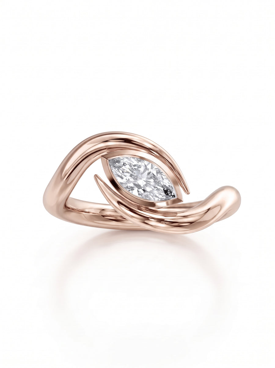 Rose gold engagement ring featuring a marquise cut diamond set within a curved, spiky bypass band.