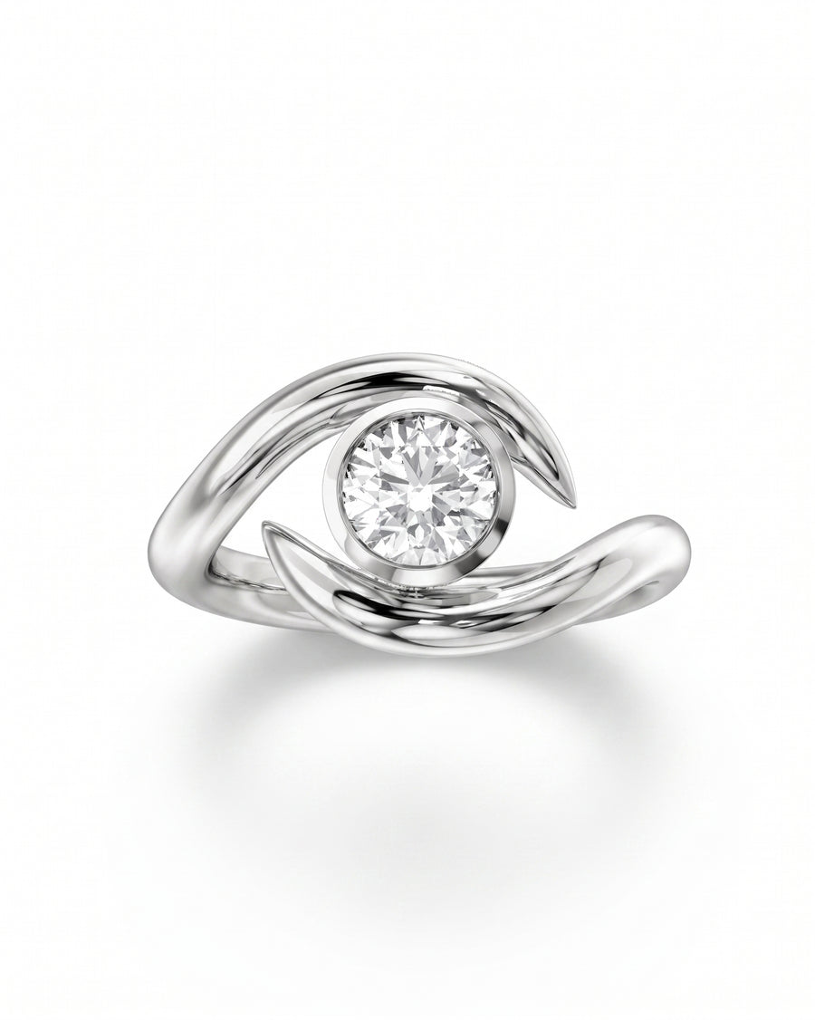 Silver round cut spiky engagement ring with a bezel-set diamond.