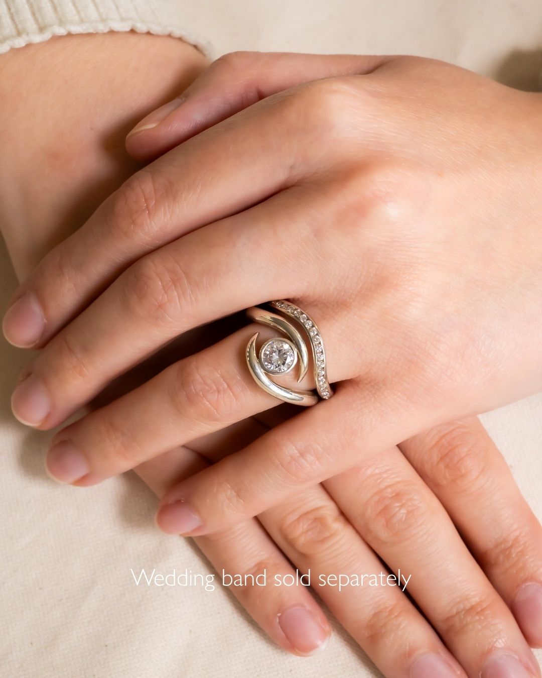 Silver round cut spiky engagement ring with a central diamond and pave accents.