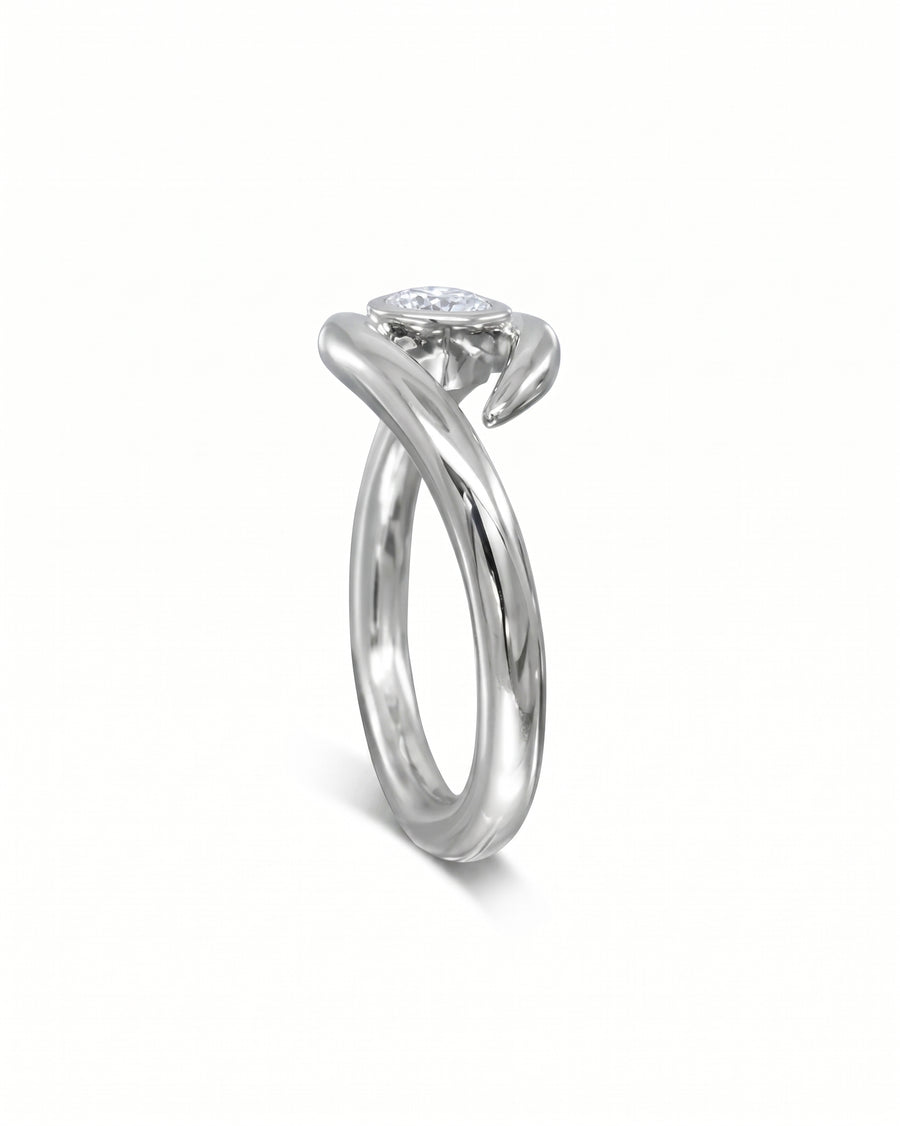 Silver round cut spiky engagement ring with a single diamond.