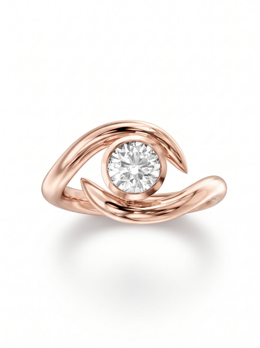 Rose gold engagement ring featuring a round cut diamond set in a curved, spiky bypass band design.
