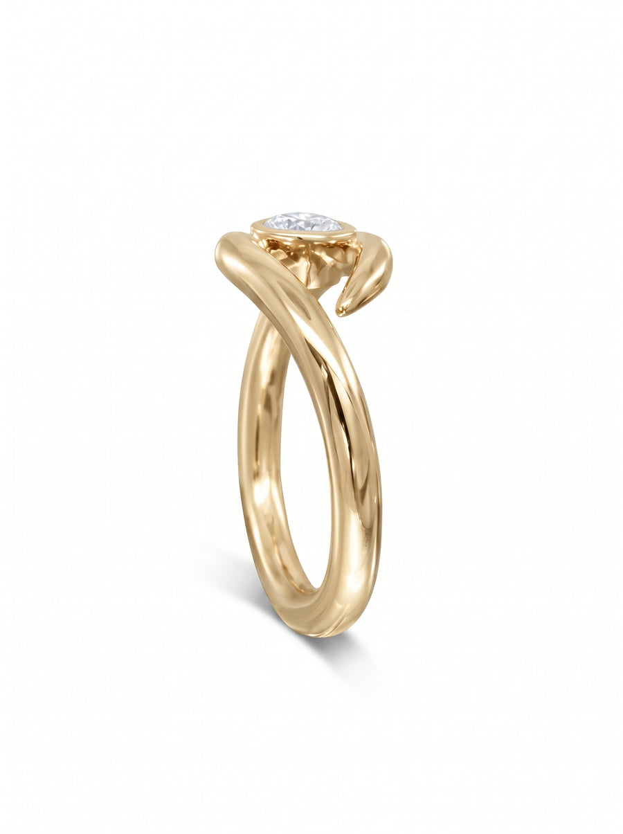 Gold engagement ring featuring a round cut diamond set in a unique, spiky, twisted metal band.