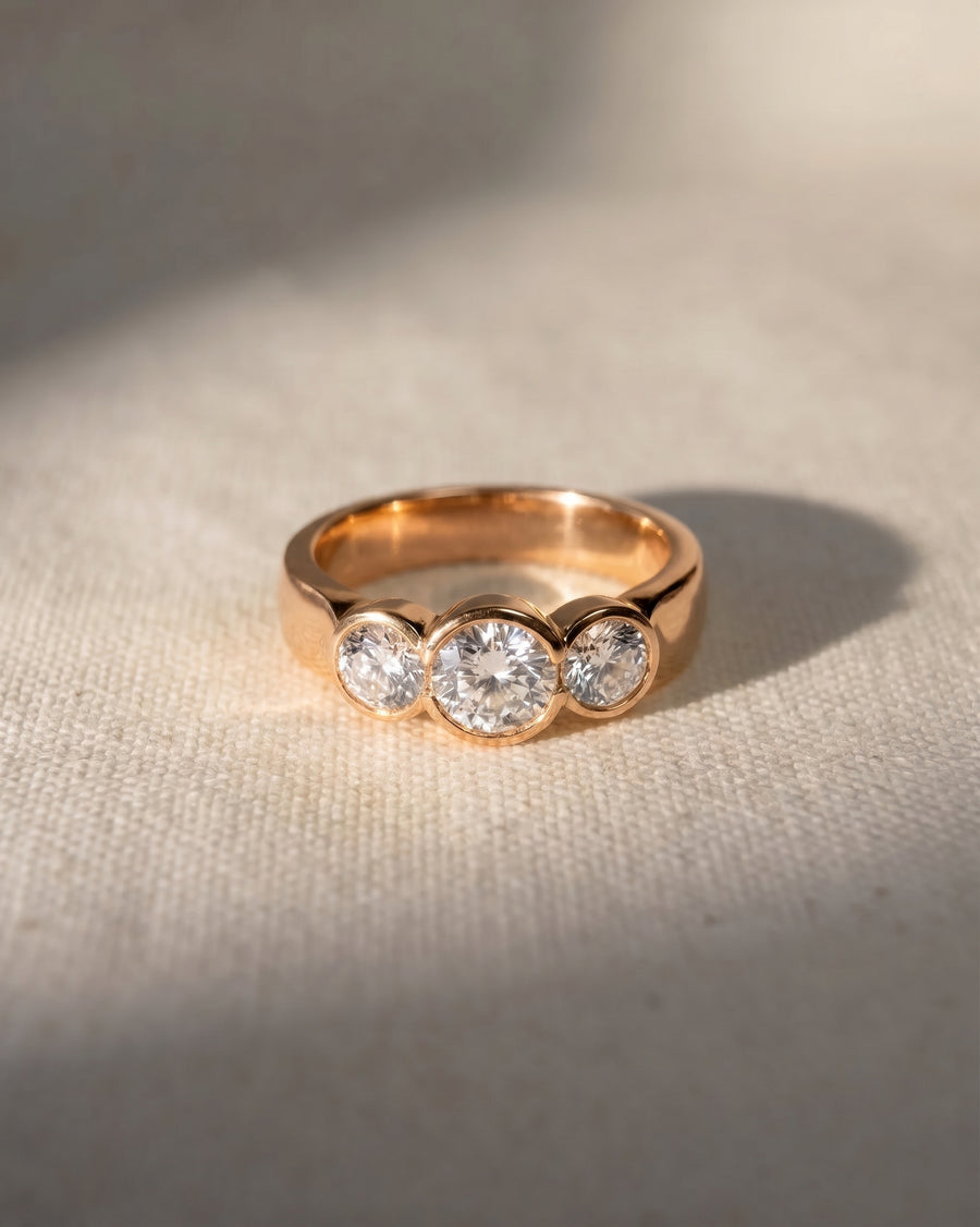 18ct rose gold trilogy engagement ring with three round lab-grown diamonds.