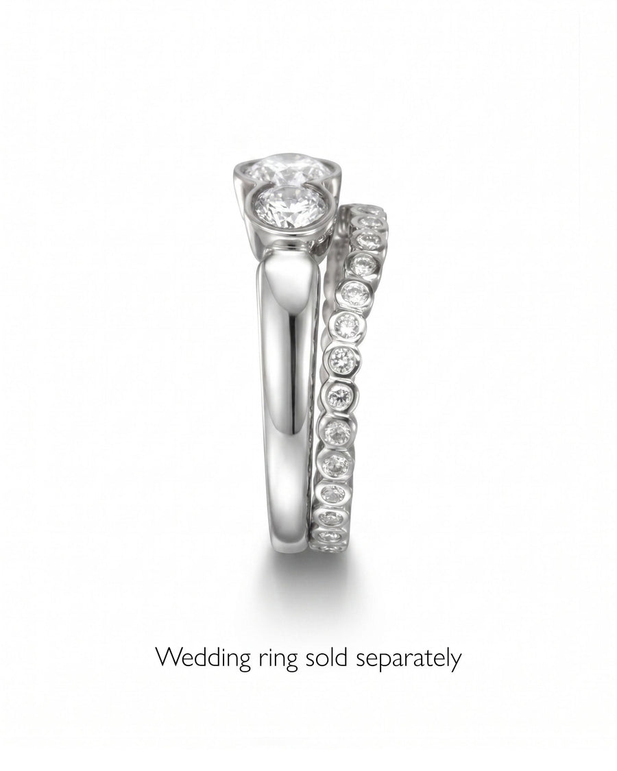 Silver round cut trilogy engagement ring with a diamond eternity band.