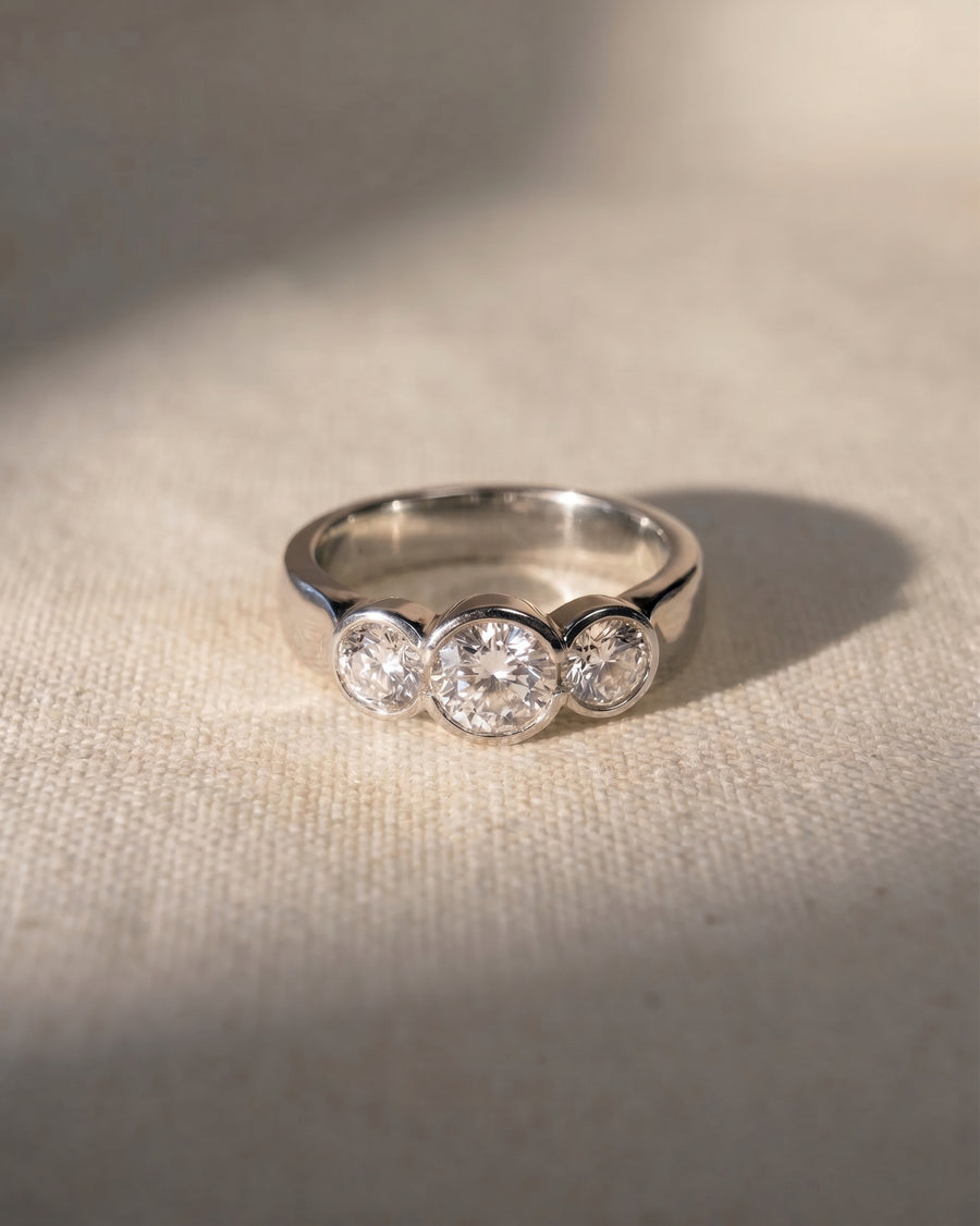 Platinum round cut trilogy engagement ring with three lab-grown diamonds.
