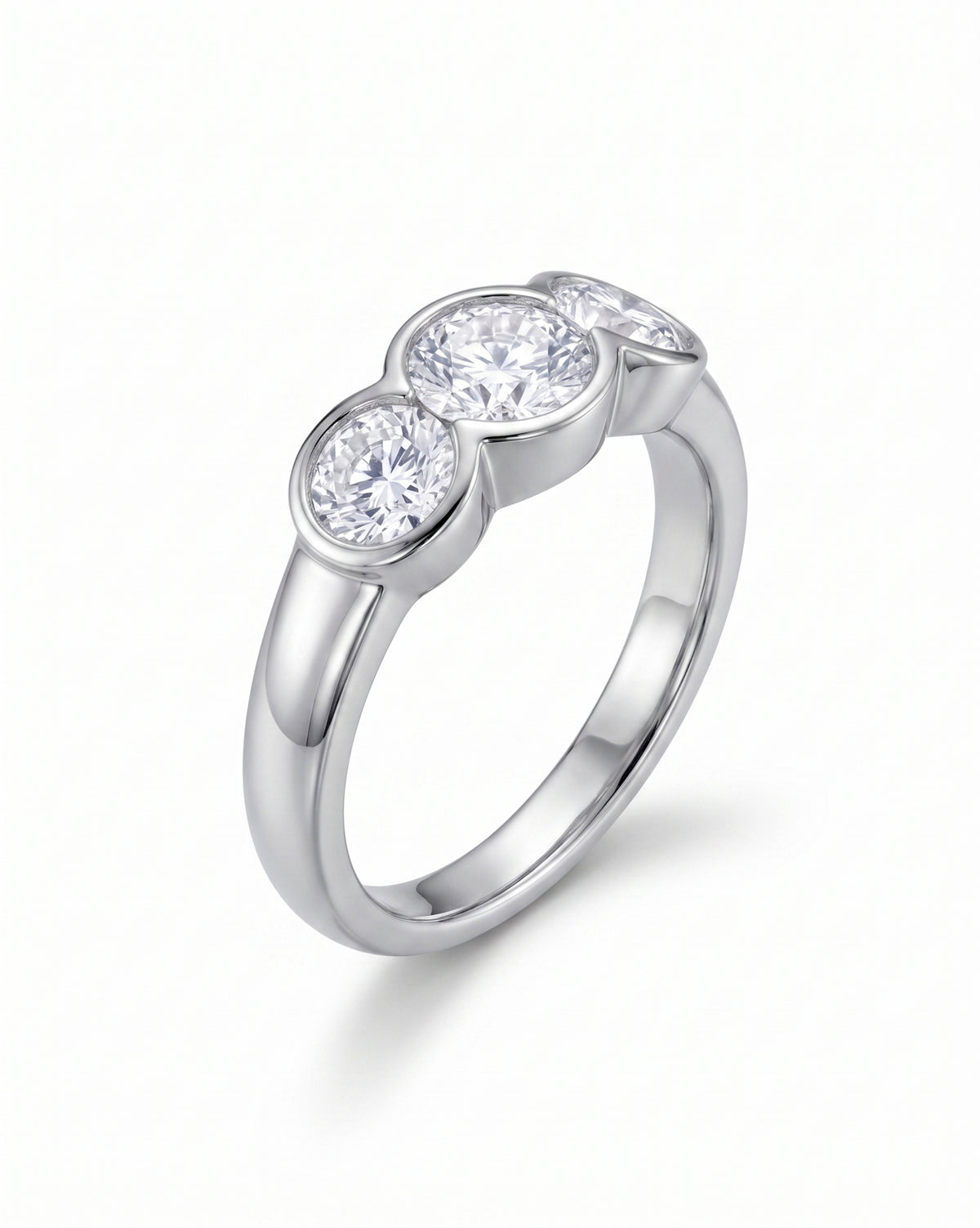 Trilogy engagement ring with three round cut diamonds in a silver-toned bezel setting.