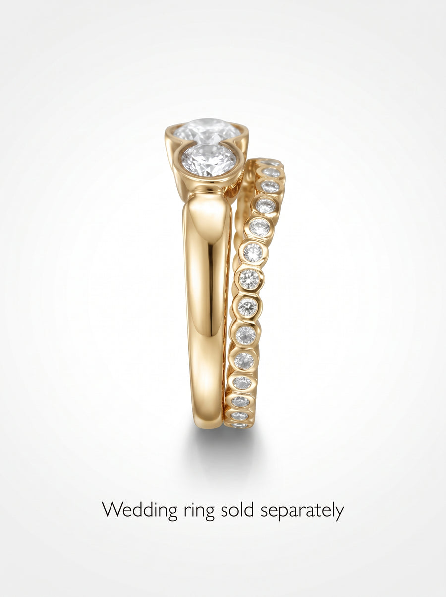 Gold trilogy engagement ring with round cut diamonds and a matching diamond eternity band.