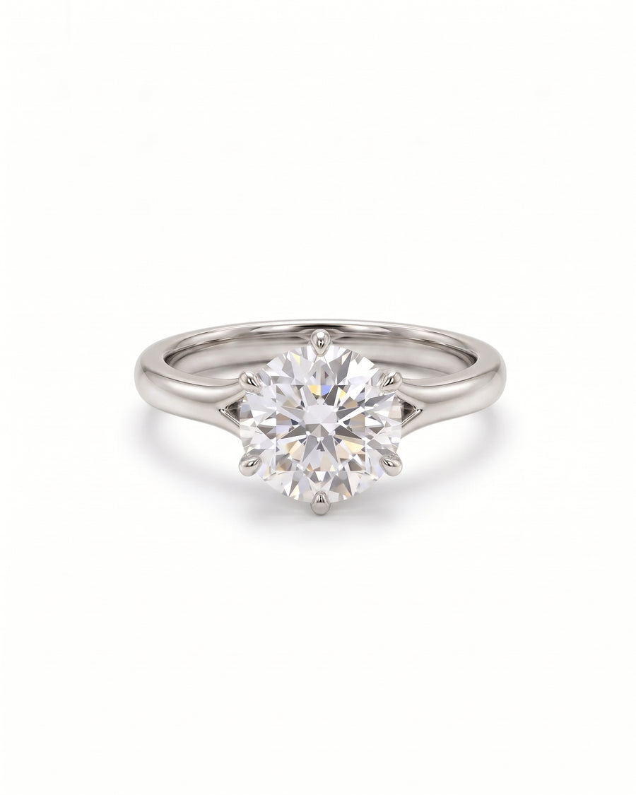 Round cut diamond engagement ring in platinum with a six-prong tulip claw setting.