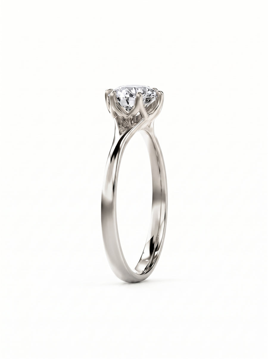 Round cut diamond engagement ring in polished white gold with a tulip-style claw setting.