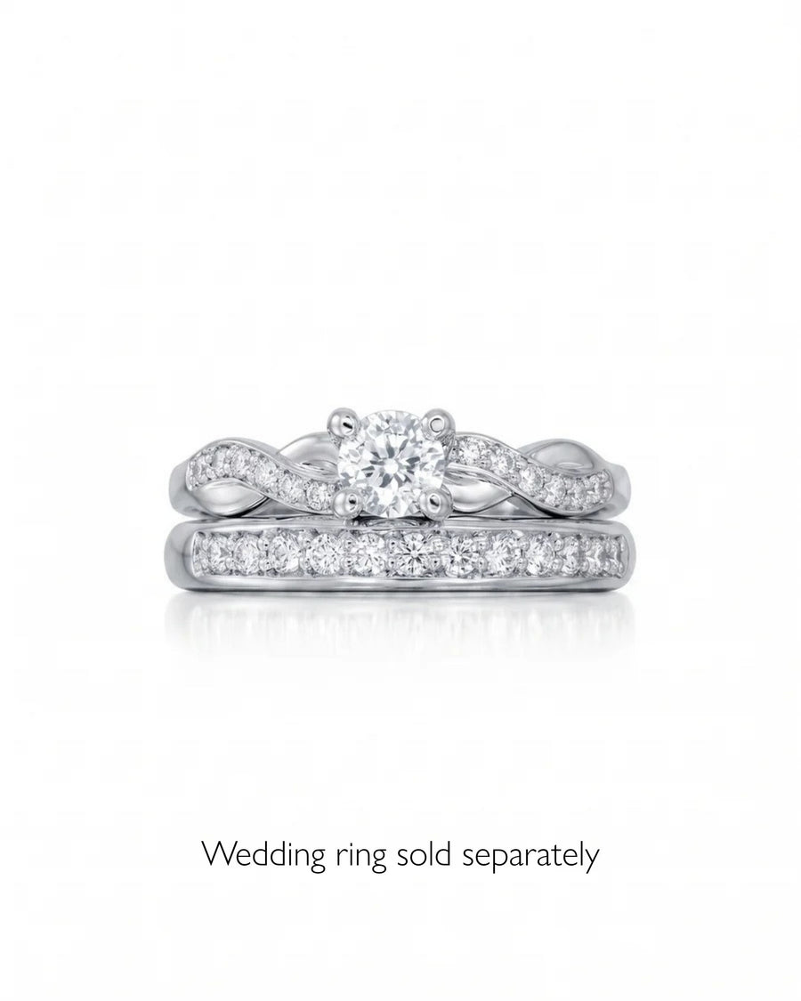 Round cut diamond engagement ring in white gold with a twisted claw setting and pavé accents.