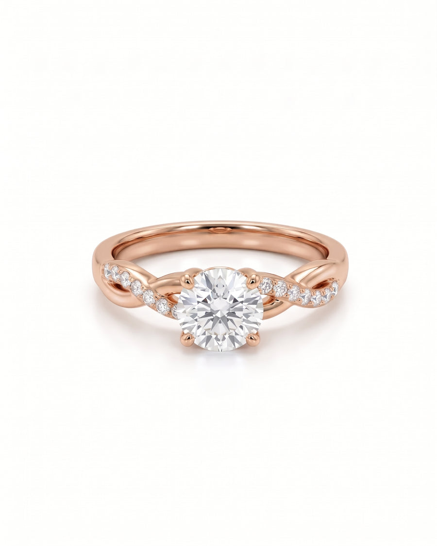 Round cut diamond engagement ring in 18ct rose gold with a twisted band and pavé set side stones.