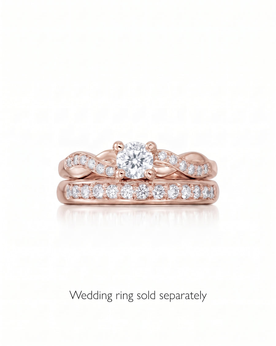 Rose gold engagement ring with a round cut center stone and twisted diamond pavé band.