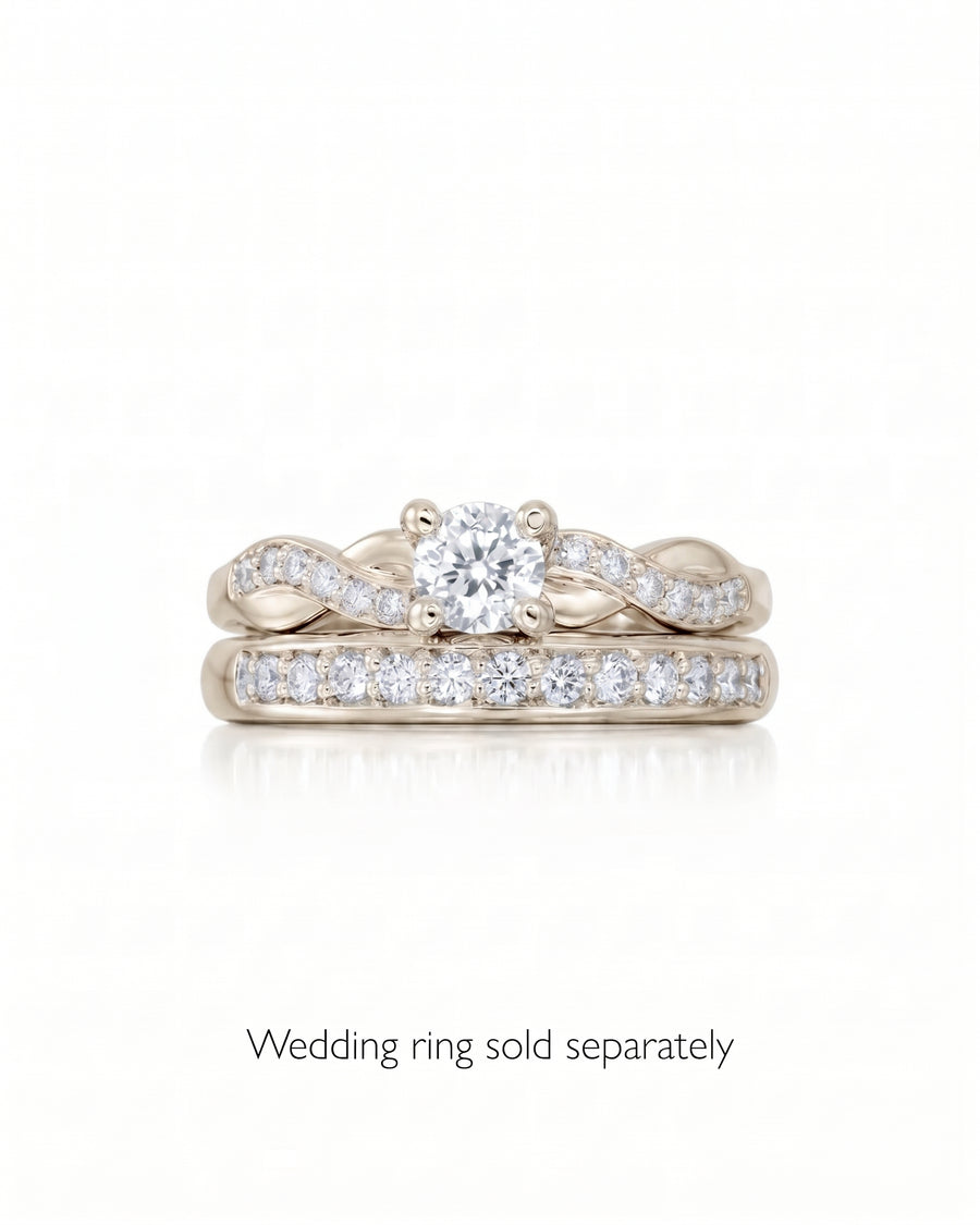 Round cut diamond engagement ring with a twisted gold band and pavé setting.