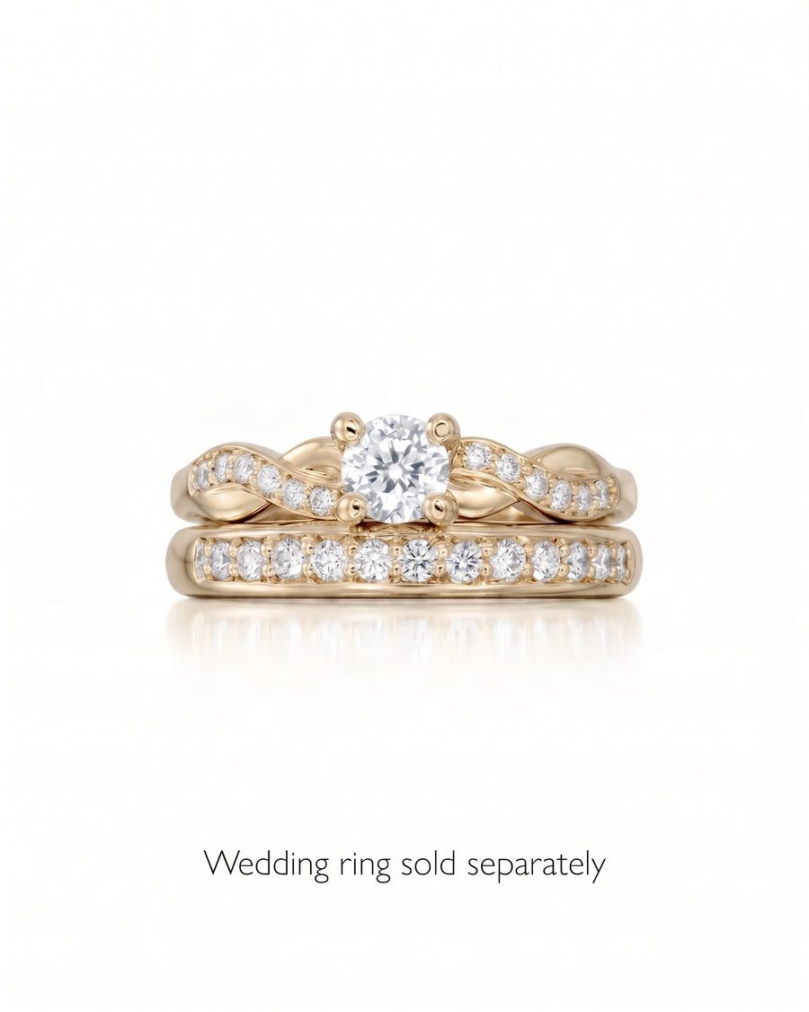 Round cut diamond engagement ring with a gold twist claw setting and pavé band.