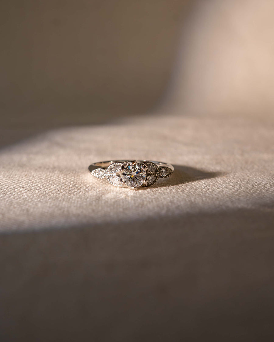 Silver round cut vintage engagement ring with a large center diamond and smaller accent diamonds.