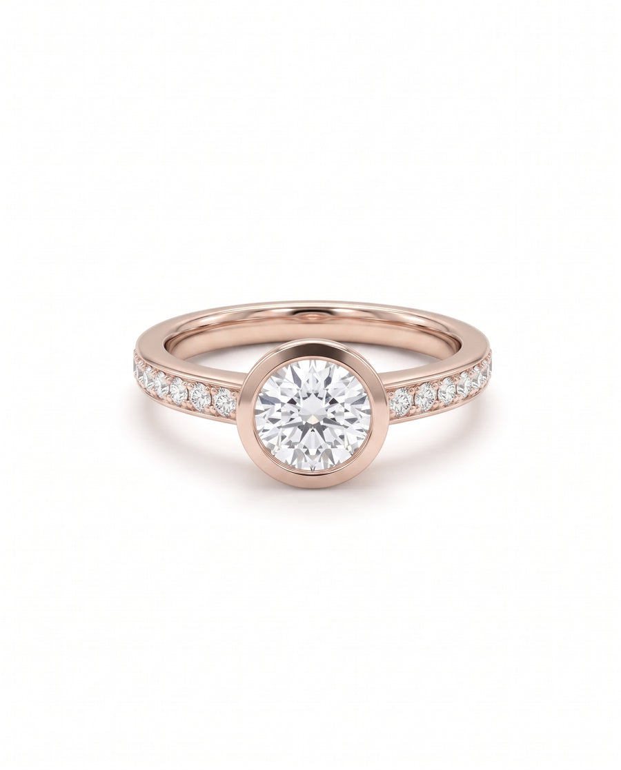Rose gold engagement ring with a round bezel-set diamond and pavé diamond band.