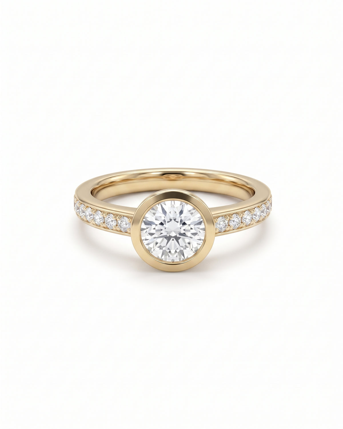 Round diamond engagement ring in yellow gold with a bezel setting and pavé diamond band.