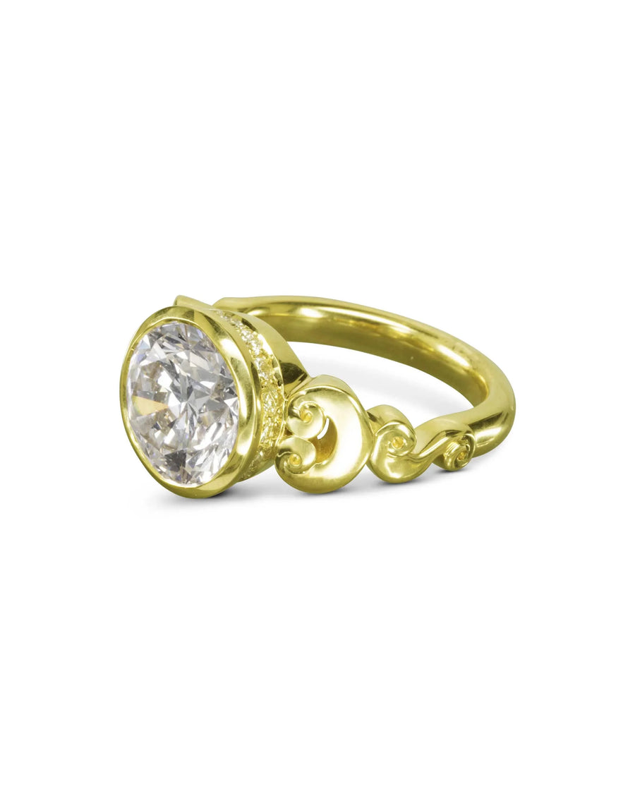 Yellow gold engagement ring with a round rub over diamond and scroll details.