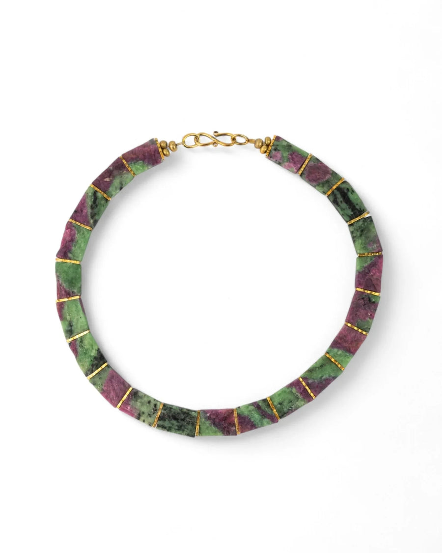 Ruby zoisite collar necklace with gold accents, geometric beads on white background