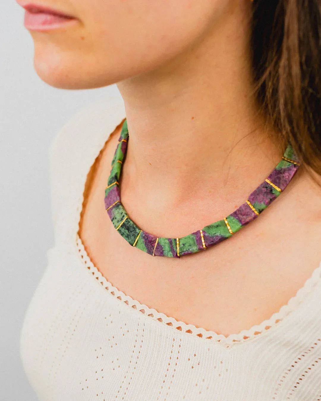 Woman wearing a chunky ruby zoisite collar necklace with gold accents