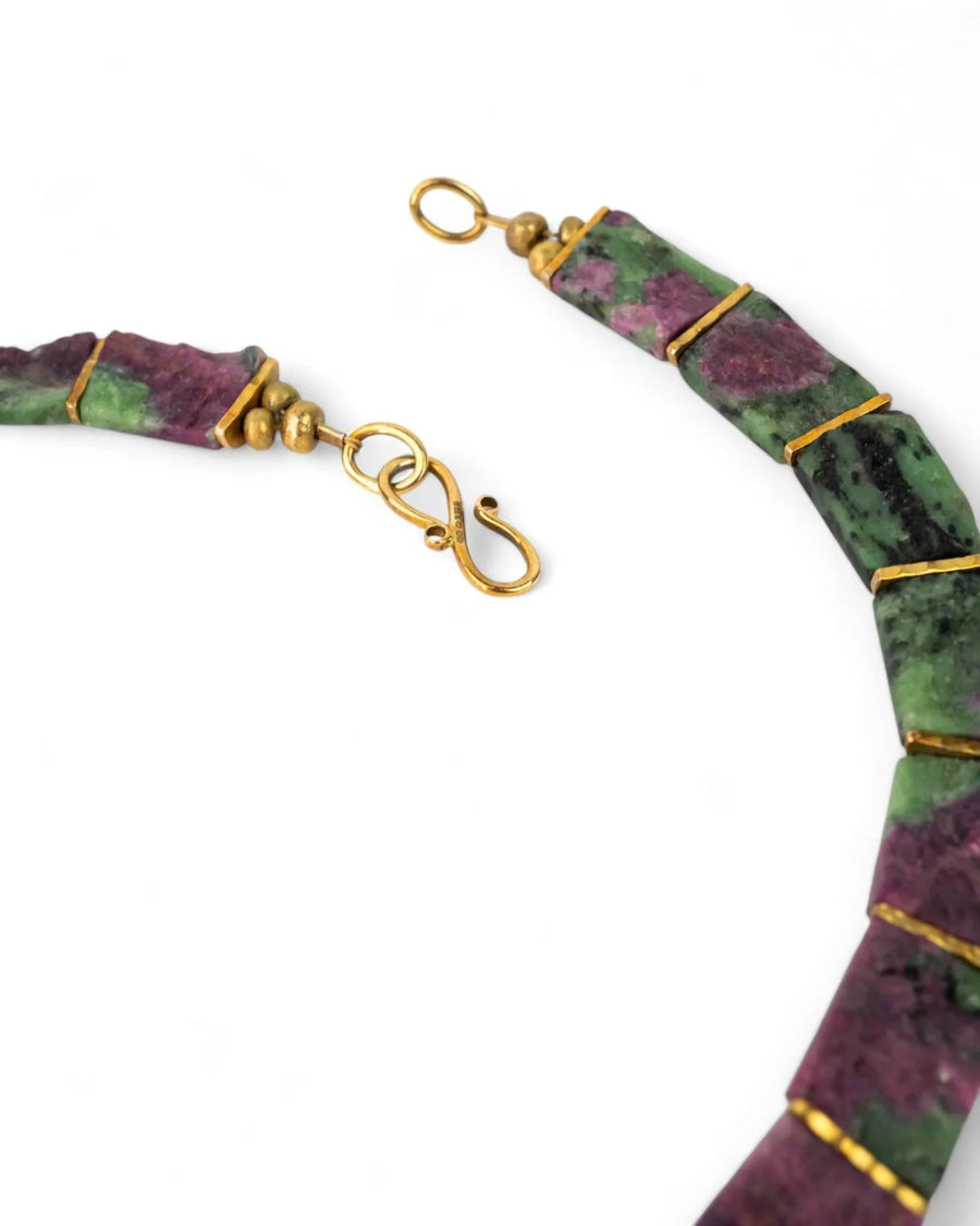 Ruby zoisite collar necklace with gold clasp and green-purple stones on white background