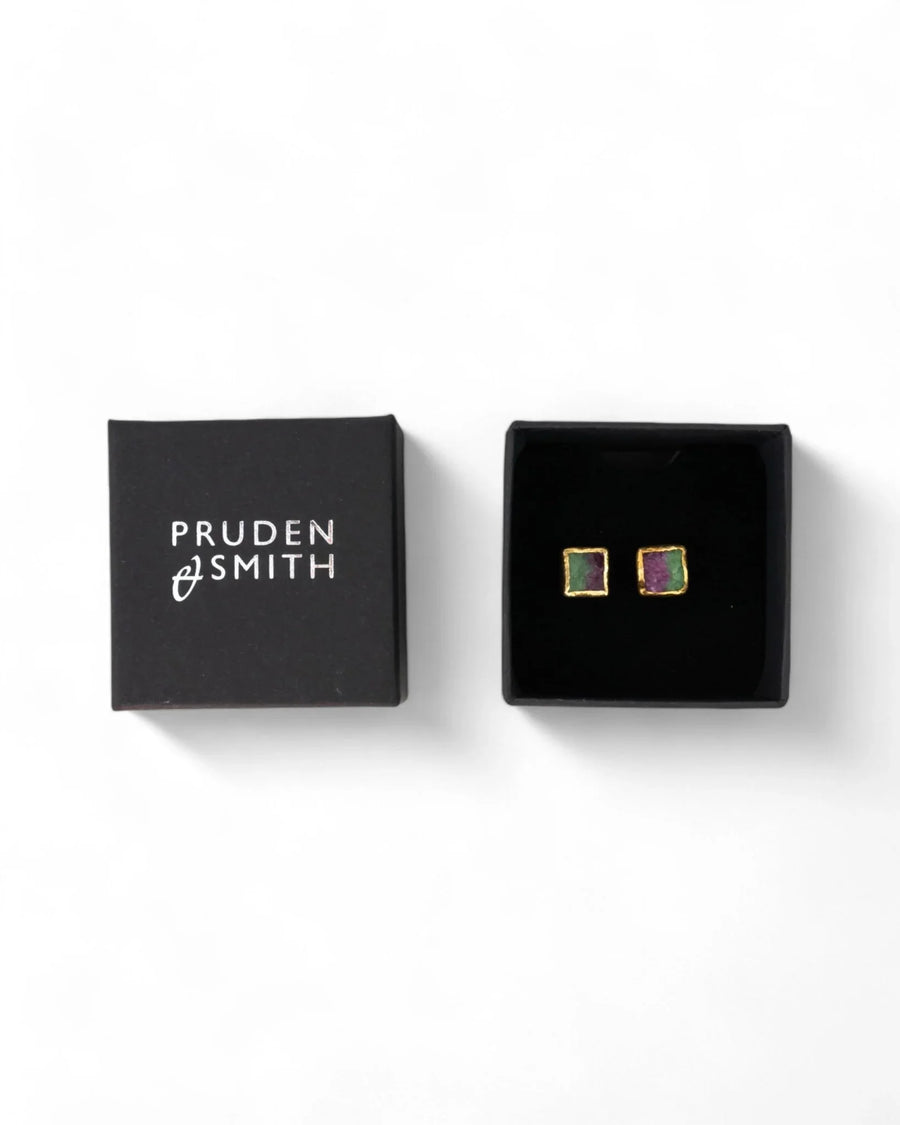 Square ruby zoisite stud earrings with gold edges in a black jewelry box