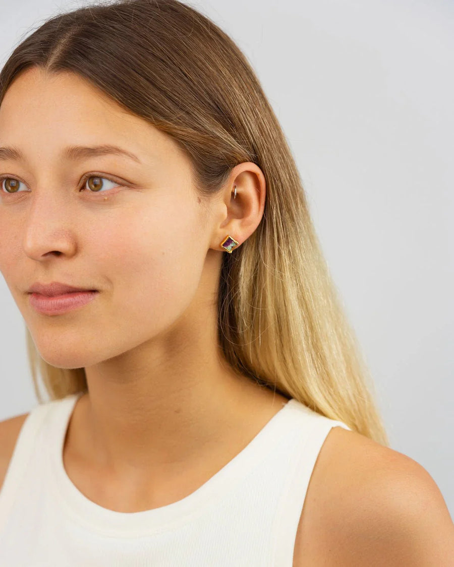 Woman wearing square ruby zoisite stud earring in gold setting