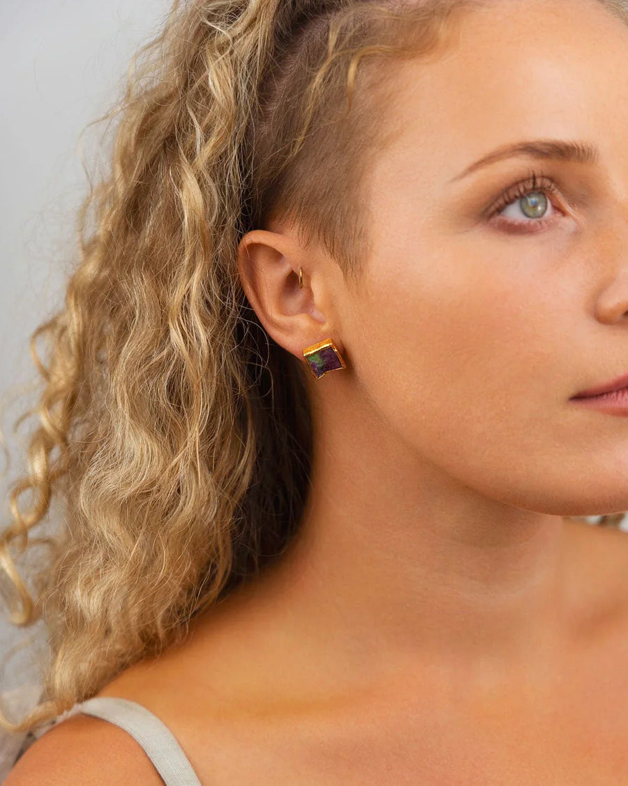 Woman wearing square ruby zoisite stud earrings with gold edges, close-up shot