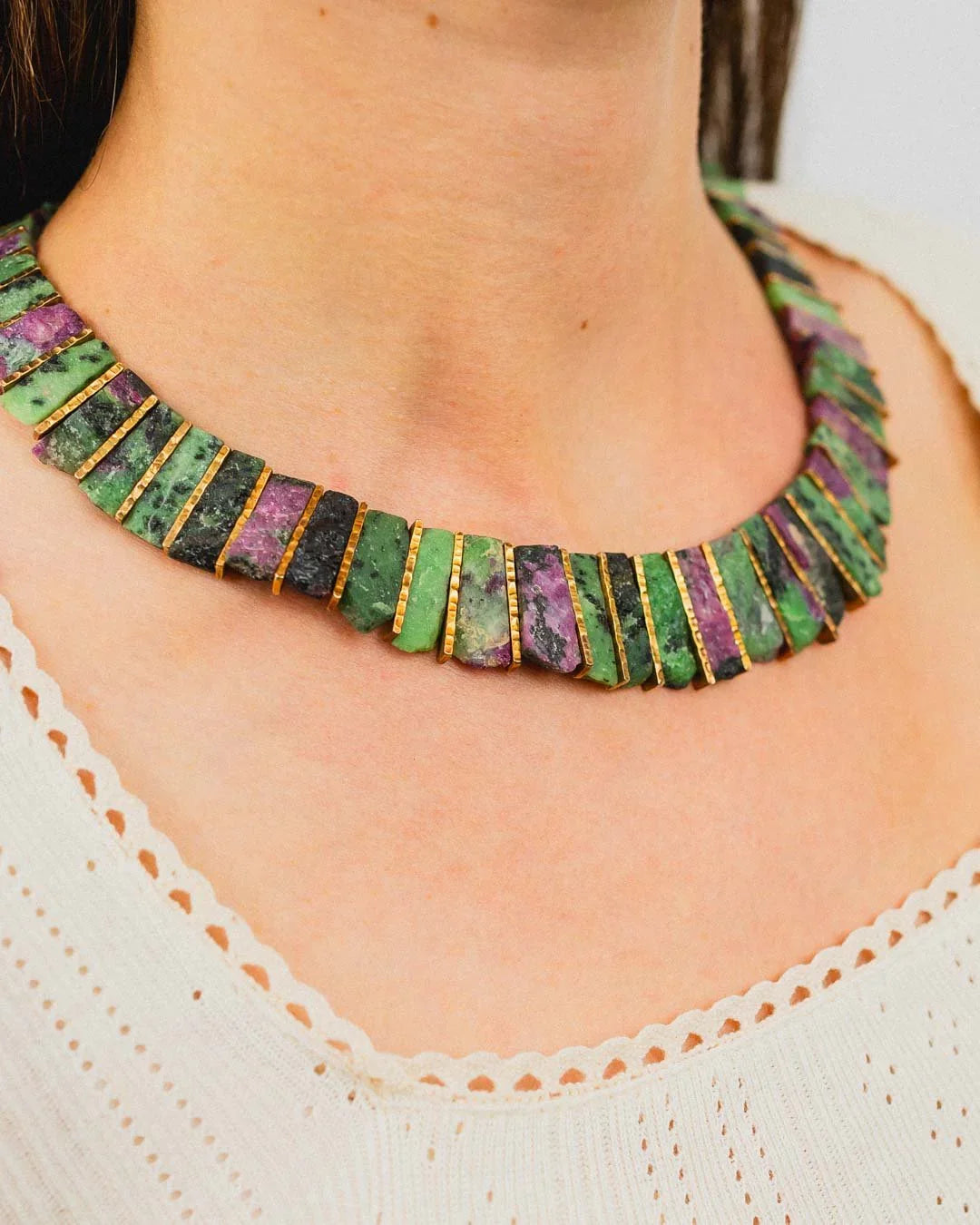 Ruby zoisite and gold tab necklace with bold organic shapes on a woman's neck