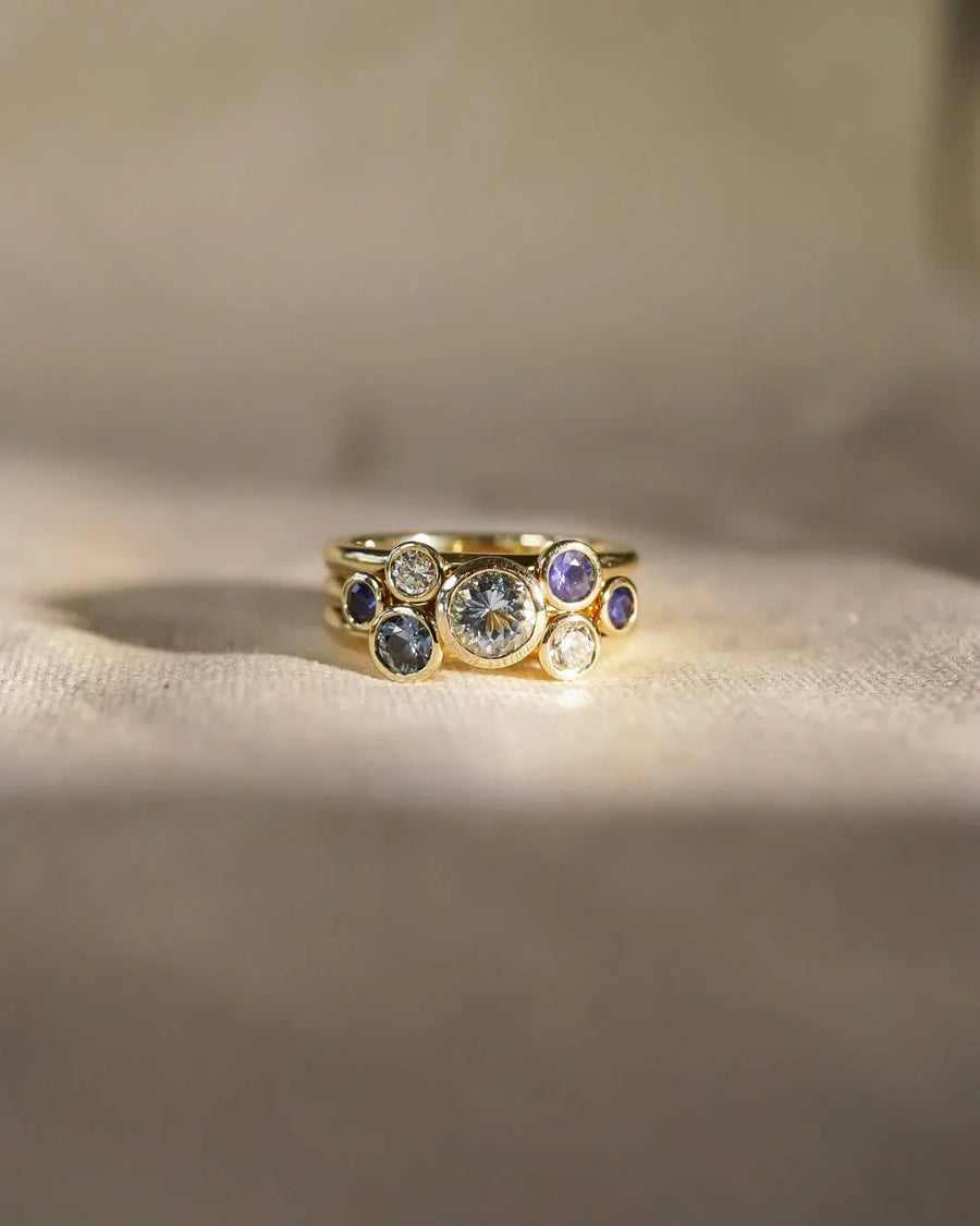 Gold stacking ring set with sapphire, aquamarine, and diamond gemstones.