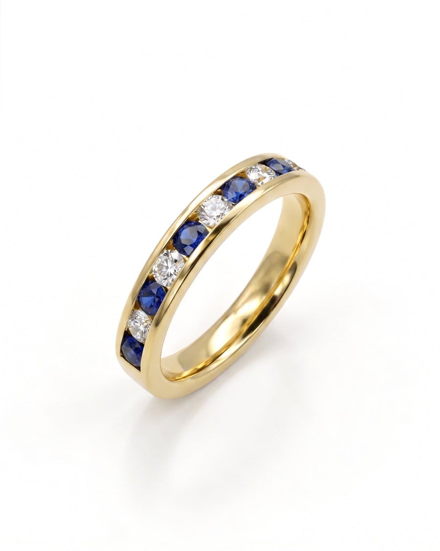 Gold eternity ring with channel-set blue sapphires and diamonds.