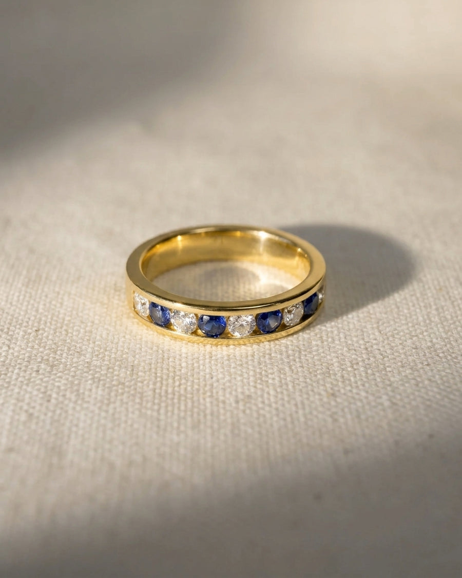 18ct yellow gold eternity ring with alternating blue sapphires and diamonds.