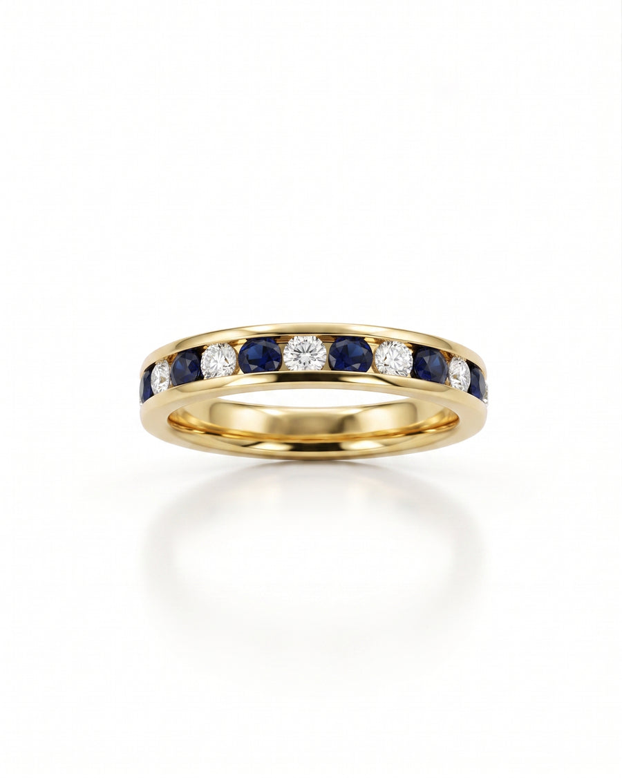 Gold eternity ring with channel-set blue sapphires and round diamonds.