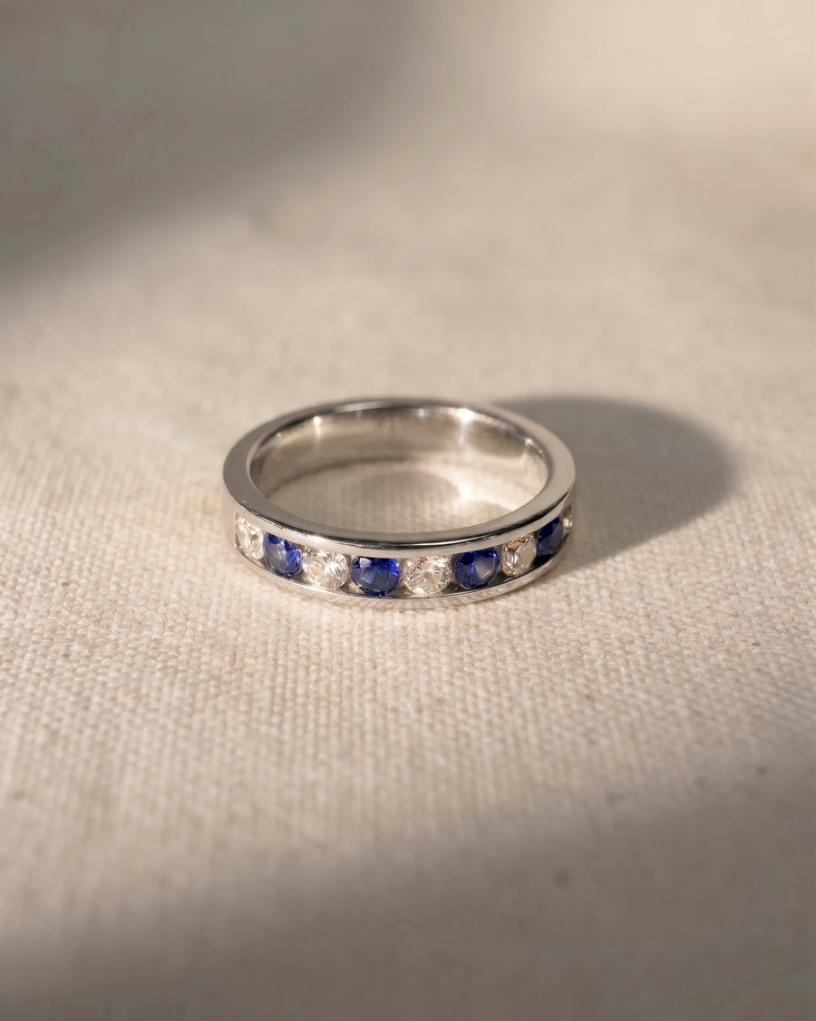 Platinum eternity ring with alternating blue sapphires and diamonds.