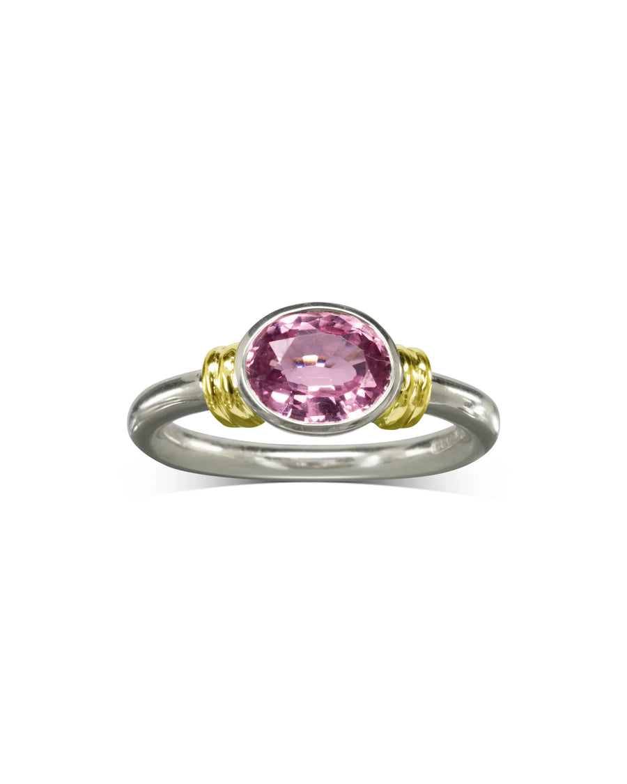 Handcrafted ring with an oval pink sapphire set in silver and gold double shoulder design