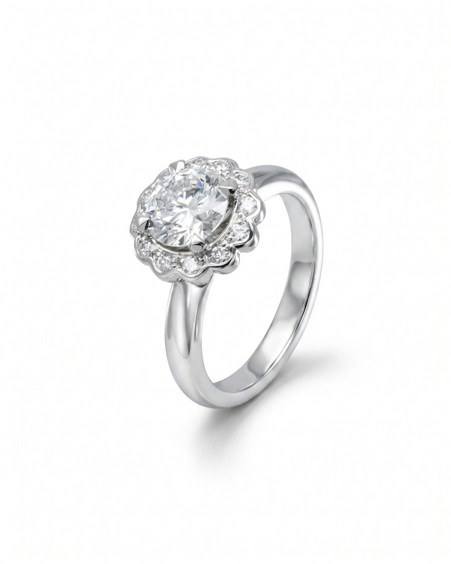 Silver scalloped diamond cluster engagement ring with a large center stone.