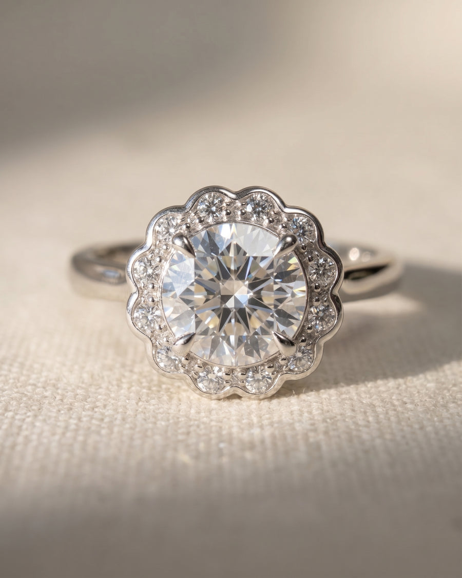 Silver scalloped diamond cluster engagement ring with a large center stone.