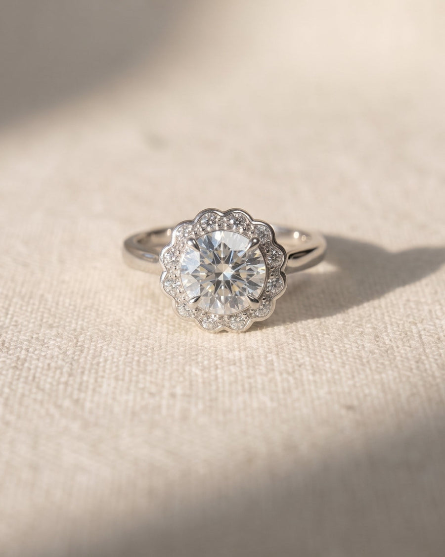 Platinum scalloped diamond cluster engagement ring with a large center stone.