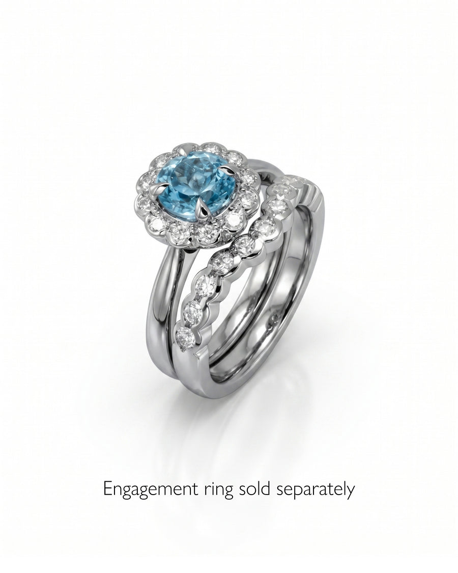 White gold scalloped diamond wedding band with matching engagement ring featuring a blue gemstone.