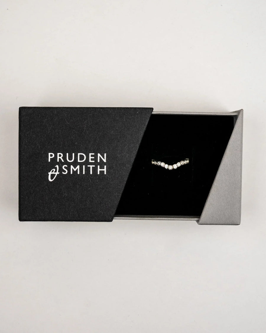 White gold scalloped diamond wedding band in a black box.